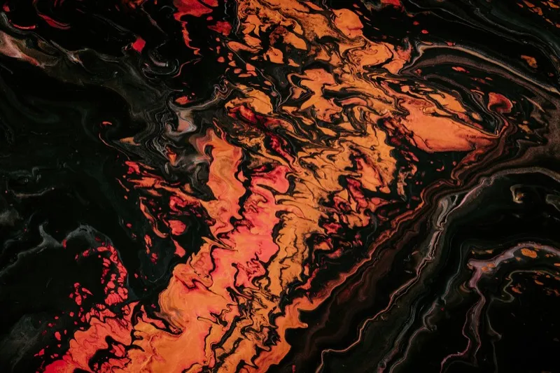 Abstract orange and black fluid painting with warm golden tones