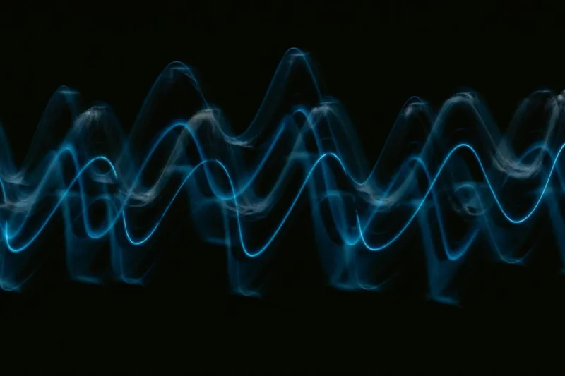 Abstract blue wave of light on black background